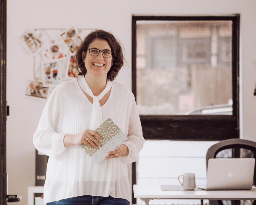 Antje mit Notizbuch in ihrem Büro